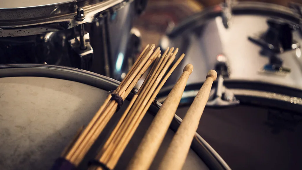Drumsticks resting on an acoustic drum kit