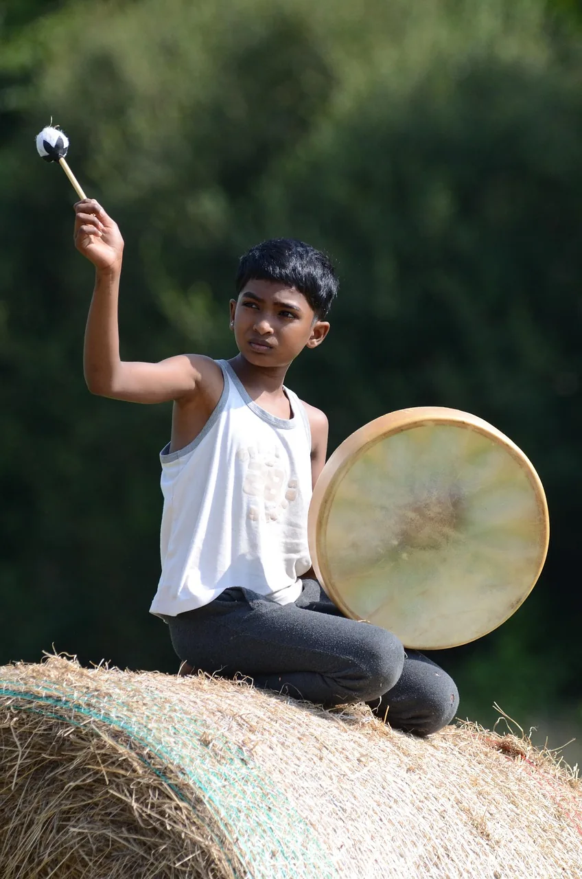 Young percussionist playing a frame drum Young percussionist playing a frame drum