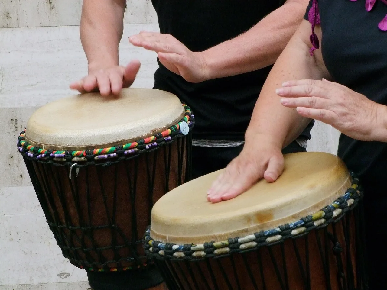 Musicians playing djembes by hand Musicians playing djembes by hand