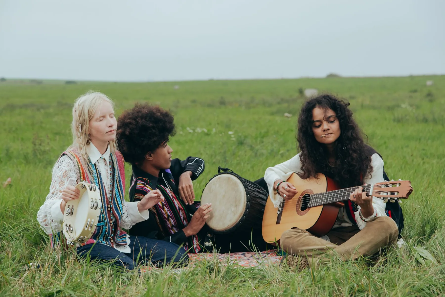 Musicians with a djembe, guitar, and tambourine